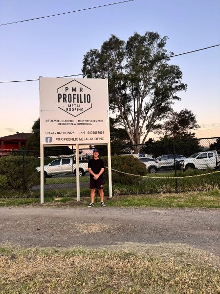 Blake from Profilio Metal Roofing with Warilla Gorillas sponsorship signage at Reddall Parade